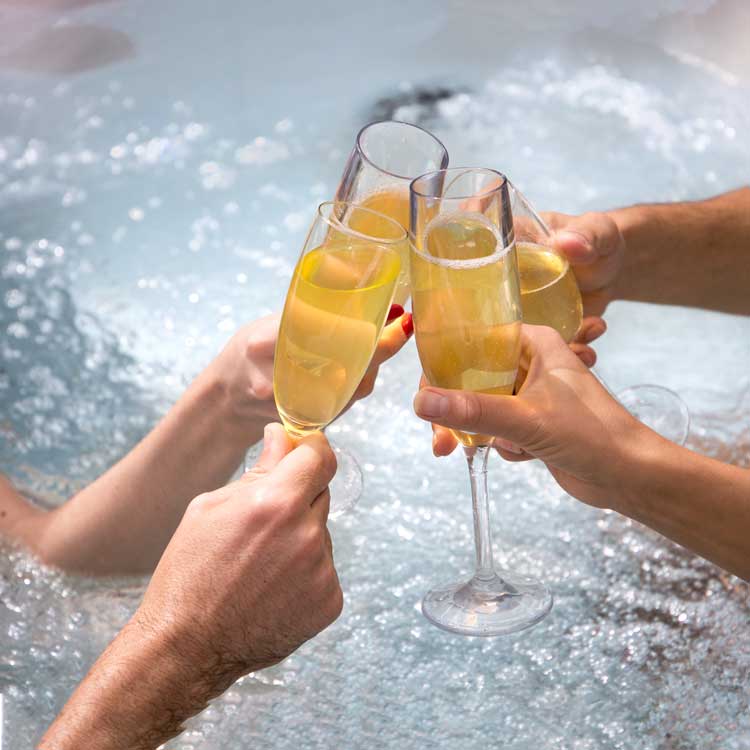 people toasting champagne in hot tub