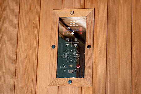 Control panel on a wooden wall with buttons and display.