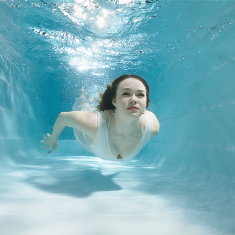 woman dives under the pool water