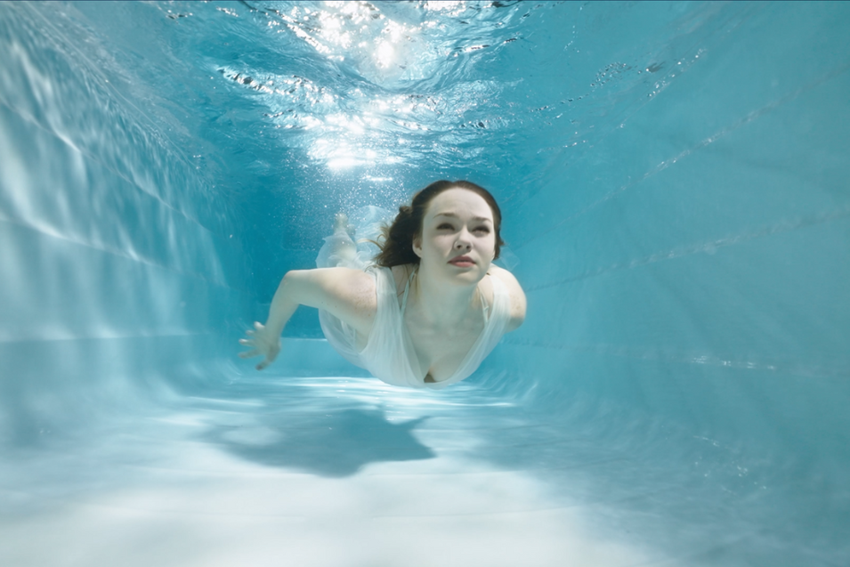 woman dives under the pool water