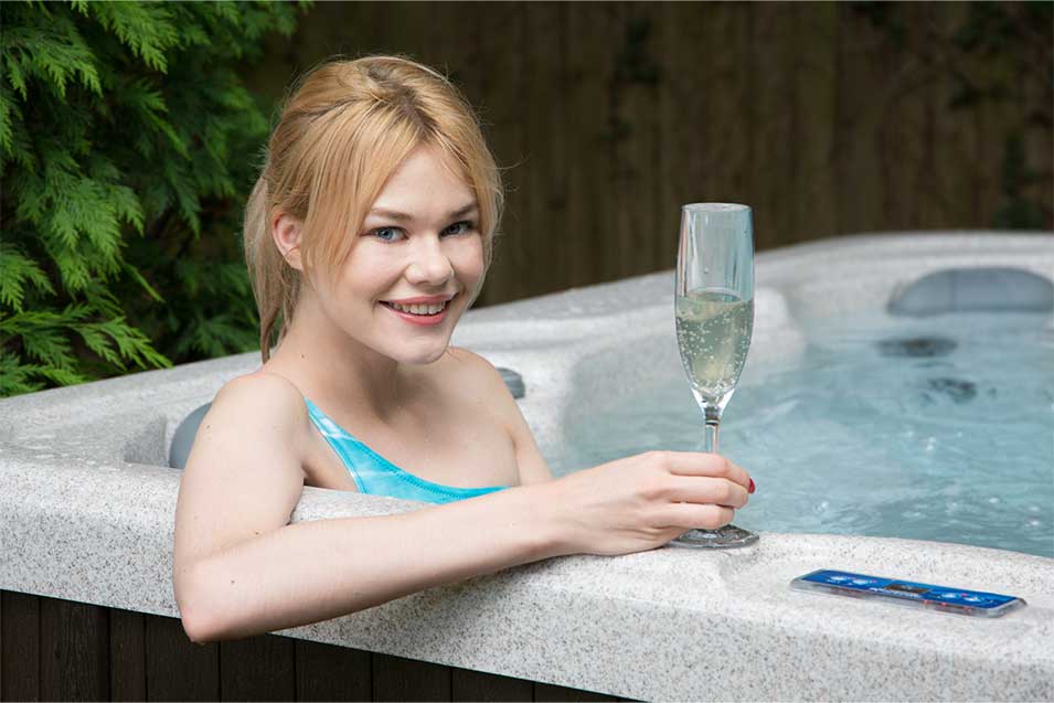 Woman drinking champagne inside the Tranquility hot tub