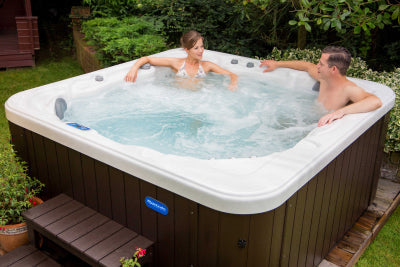 Couple relaxing in a Riptide hot tub in their garden.