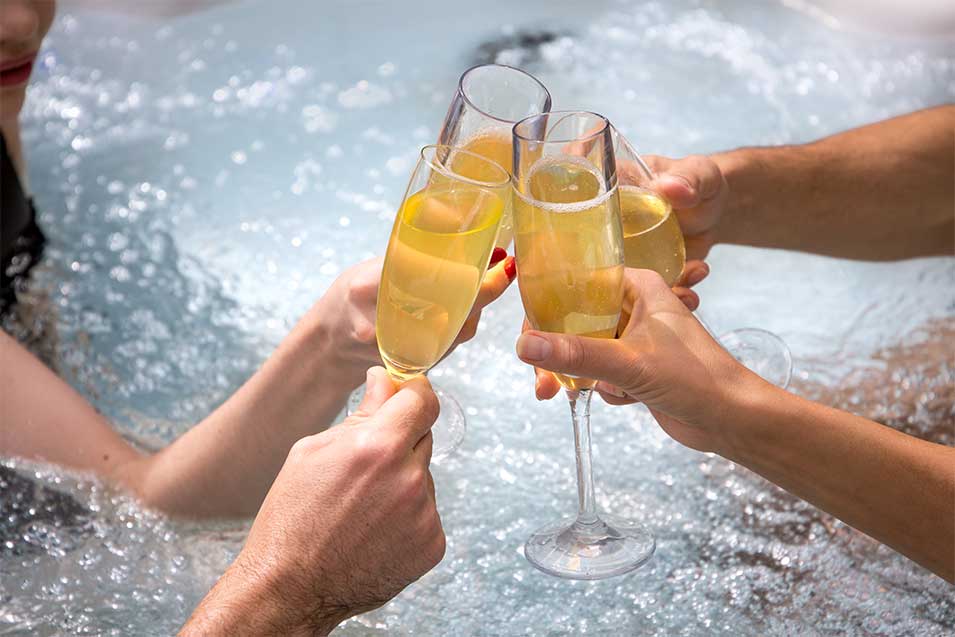 people toasting champagne in hot tub